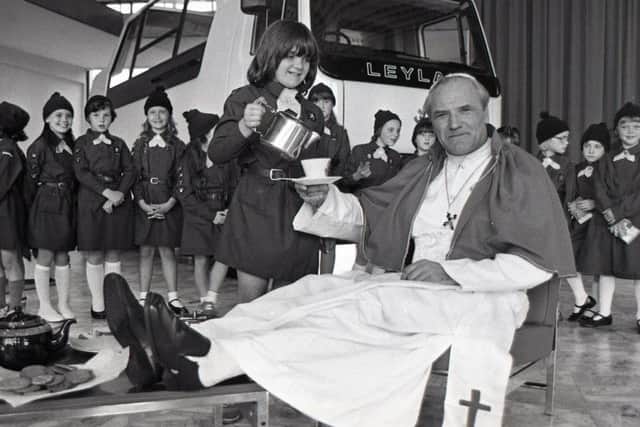Pope John Paul II puts his feet up while Sarah Moss of Leyland Brownies pours the tea. The surprise was part of a national challenge in which thousands of brownies arranged the most unusual tea-party. The Leyland Brownies chose to stage theirs in the world famous Popemobile